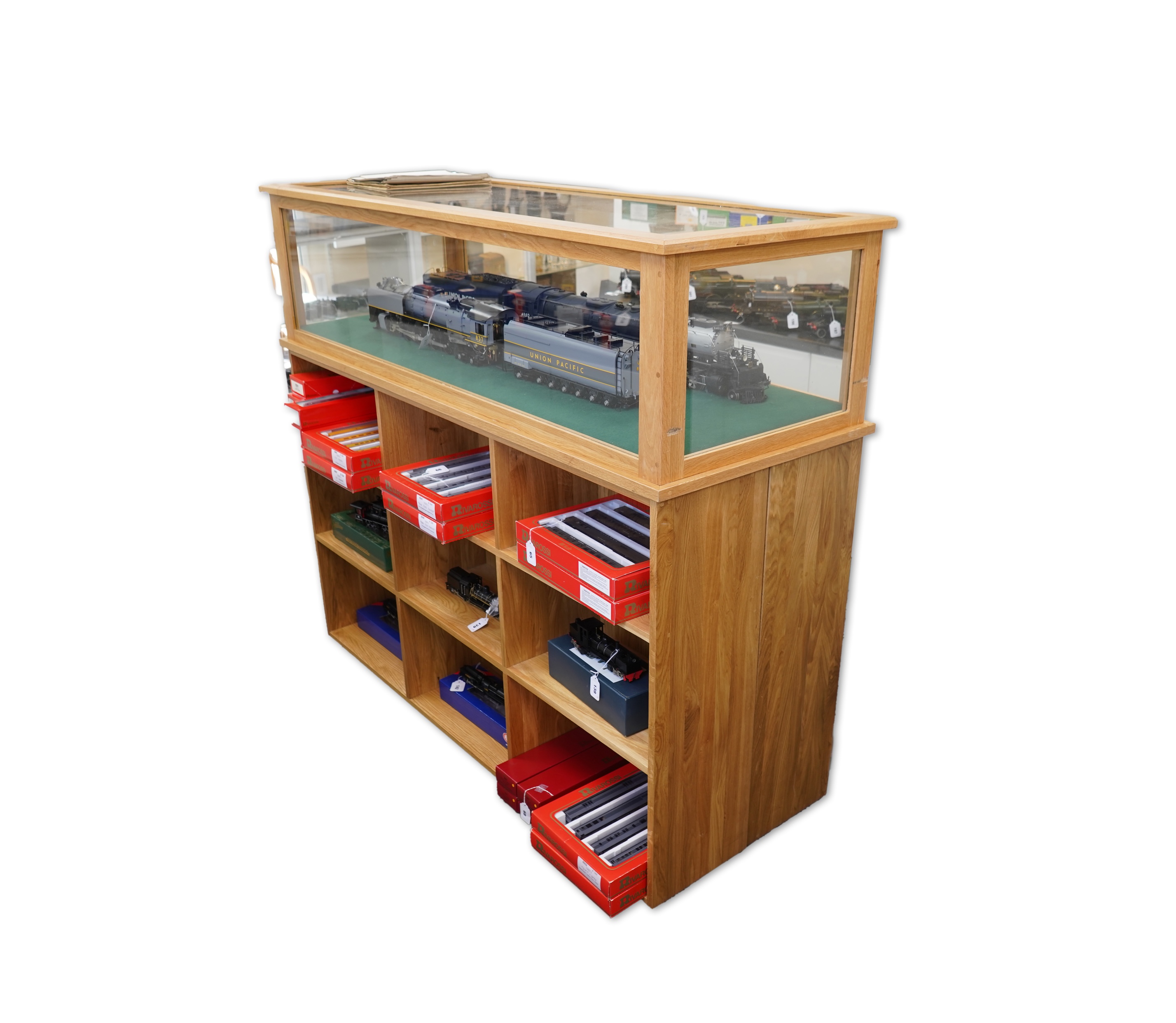 An engineered oak display stand, with a removable glazed top, and double sided base divided into nine compartments on each side, dimensions; 160cm wide, 60cm deep, 141cm high (contents for display purposes only and not i